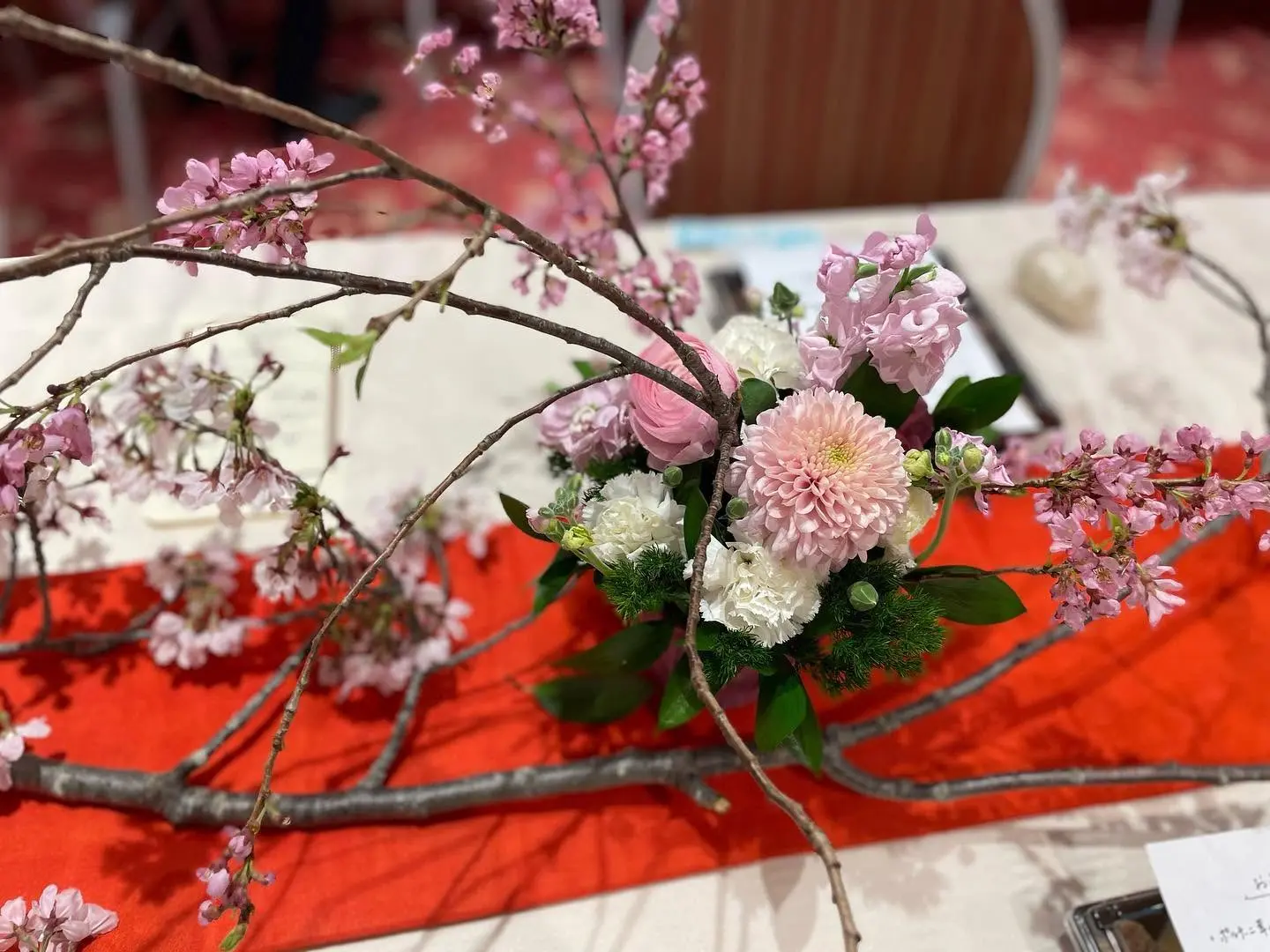 桜の枝を広げた、祝いの席のテーブル装花