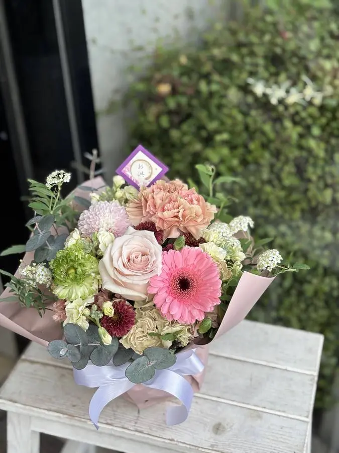 お祝いの札を添えた、ピンクと白のギフト花束